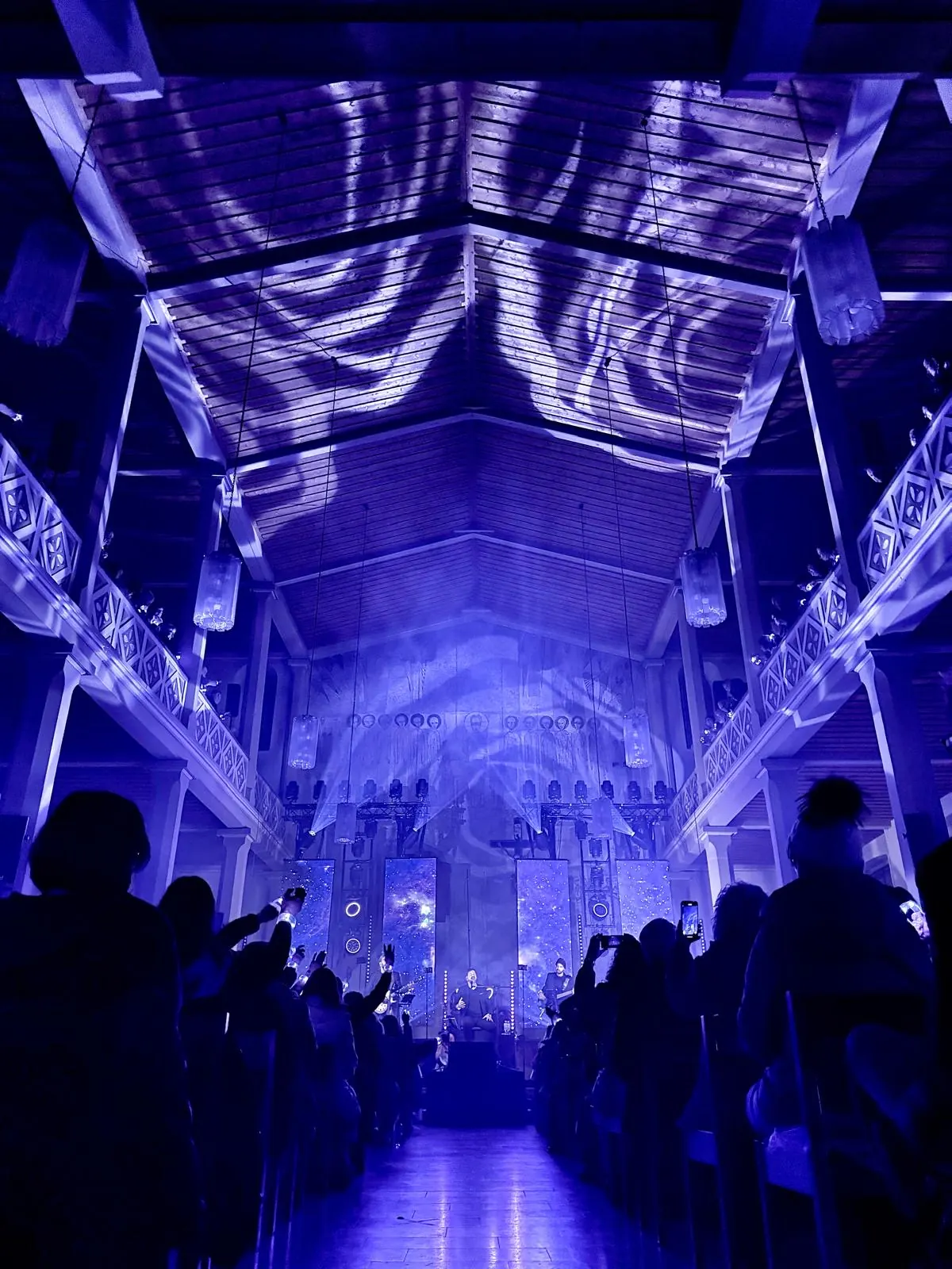 Kirche mit Holzdecke, auf die blaue Lichtmuster projiziert werden